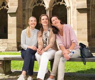 Besucherinnen des Klosters Maulbronn sitzen auf einer Bank